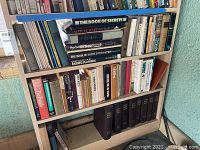 Books arranged on wooden shelves, showing diverse topics and visible titles including The Book of Secrets and Encyclopedia of Estate Planning.