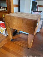Full side view of butcher block kitchen island showing block top and caster wheels