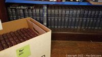 Row of blue-bound Harvard Classics volumes on wooden shelf
