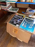 Photo showing box labeled 'Jewelers' Circular Keystones Magazines' with two magazine covers visible on top: Art Jewelry and Gems & Jewelry