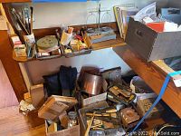 Wooden shelf with trays of brushes, flux jar, polishing stones, small tools and a box of supplies below