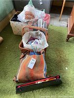 Overview of lot showing woven fabric bag, baskets, yarn, and sewing items on green carpet