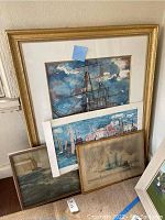 Four framed nautical-themed wall art pieces leaning against a wall