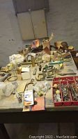 Overview of vintage tools and hardware on workbench and in trays