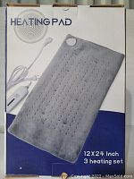 Photo of the product box showing the heating pad in gray, with controller attached, 12x24 inch size, and 3 heat settings