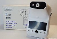 AI infrared thermometer device with camera and LCD display on a white background, along with original product box showing illustration and product features.