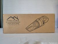 Original cardboard box of Honiture cordless handheld vacuum cleaner, box has text and illustration of vacuum.