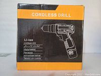 Photo of the unopened box of a cordless lithium ion drill, black and orange packaging.