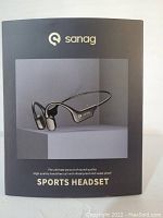 Front view of the product box showing Sanag sports headset image and branding, highlighting quality and waterproof features.