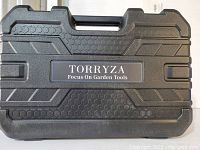 Closed black hard plastic carrying case with Torryza branding and handle on top.