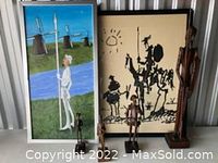 Both framed prints and three wooden figurines displayed together