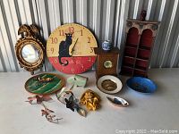 Full view of all items in the lot including clocks, mirror, plates, figurine, and wall art.