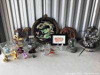 Overview of all dragon figurines and fountain on a table against a silver storage wall