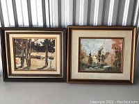 Two framed landscape paintings showing nature scenes with trees. Left painting uses brown tones and right painting is more colorful. Both framed and matted.