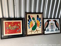 All three framed art prints displayed side by side on a white surface against corrugated metal wall