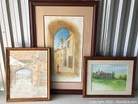 Set of three framed art prints displayed together showing varied architectural and landscape scenes.