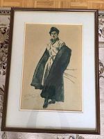 Front view of framed art depicting a woman in a dark long coat with hat, showing the full artwork and frame.