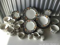 Full view of Mikasa Garden Harvest Intaglio dinnerware set arranged on table showing plates, bowls, mugs, creamer, sugar bowl, salt and pepper shakers