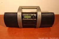 Front view of the black and silver Sirius SubX1C satellite radio with handle, control buttons, and display.