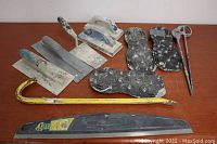 All tools arranged on a wooden surface including trowels, edgers, bull float handle