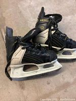 Pair of black and white CCM Tacks hockey skates, size 13, showing exterior wear and scuff marks.