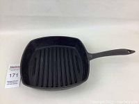 Square cast iron grill skillet showing ridged cooking surface and handle, front view