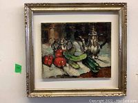 Framed oil painting still life with silver teapots, tomatoes, cucumber and green onions on white cloth.
