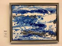 Full view of framed abstract fluid painting showing blue, white and black swirls.