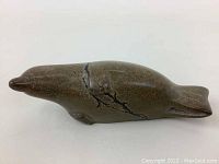 Side view of the handmade stone seal sculpture, showing the smooth surface and natural vein pattern.