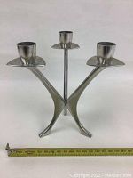 Front side view of pewter candelabra showing three curved arms with candle holders.