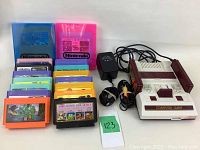 All components displayed together: console, cartridges, adapter, cable