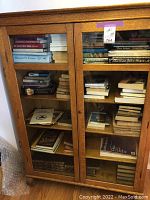 Front view of oak bookcase filled with books