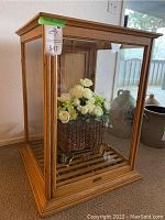 Three-quarter front view of oak display case with basket and butterflies inside