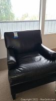 Front view of black leather armchair showing overall style and condition.