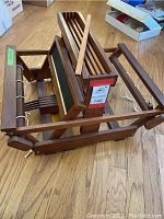 Overview of unfolded wooden table loom showing frame, beams, pedals.