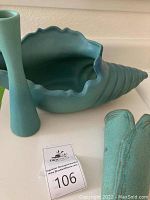 Shell vase and slender bud vase displayed on tabletop showing shape and glaze