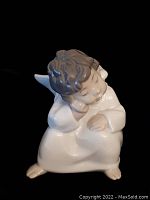 Front and top partial side view showing the angel's face, hair, wings, and white robe with a glossy finish.
