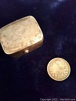 Photo showing the silver pill box and the Canadian 5 cents coin side by side on a dark surface.