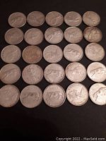 Overhead view of all 25 coins arranged in a 5×5 grid on a dark background.