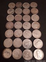 28 silver Canadian quarters arranged in rows showing obverse and reverse sides