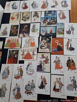 Photo showing multiple postcards laid out with various traditional folk costumes, floral designs, and scenic images.