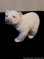 Front-facing view of glossy white porcelain polar bear figurine standing on all fours with detailed features.