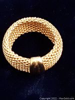 Photo of gold filled sterling silver ring showing woven mesh band and polished centerpiece