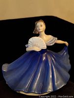 Front view of Royal Doulton porcelain figurine showing a female dancer in blue dress holding a white fan
