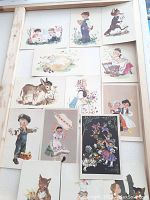 Full set of 14 vintage postcards laid flat. Variety of subjects including children, animals, and folk costumes.