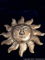 Full view of the vintage sterling silver sun face brooch showing the entire piece with stylized sun rays and detailed face design, showing tarnish and wear.