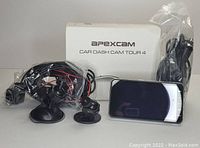 Photo showing Apexcam Car Dash Cam Tour 4 with main camera, mounting accessories including suction mounts, cables, and original packaging box.