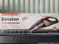 Front side image of boxed Banaton 106W car vacuum cleaner showing product image and key features such as low noise, strong suction, washable filter, wet and dry use, 5 meters power cord.