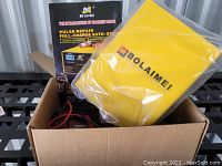 Image of BO LAI MEI branded yellow smart battery charger with cables inside a cardboard box with product packaging.