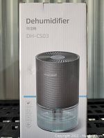 Photo of front side of the dehumidifier box showing model DH-CS03 and product image